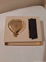 Heart-shaped gold-tone compact in original box with soft black protective case.