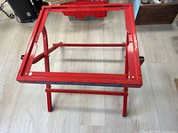 Top view of the red rectangular frame of Bosch table saw stand showing the metal structure.