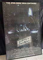 Full view of the framed Star Wars The Empire Strikes Back movie poster with Darth Vader image and starfield background.