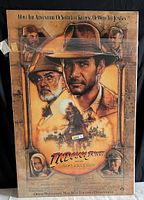 Full view of the Indiana Jones and the Last Crusade framed movie poster showing detailed illustrations of characters and movie title.