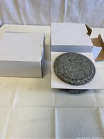 Two new Korean stone pots in white cardboard boxes. One lid visible with speckled gray stone texture.