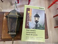 Rust finish post lantern next to its Retail box with model 0048370 and Portfolio Outdoor brand visible