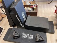 Six black Race Ramps vehicle ramps and triangular supports with maximum load of 1500 lbs marked, made by Brute Technologies in USA, arranged on floor.