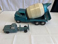 Full side-on photo of the large cement mixer toy next to the smaller diecast truck, showing overall condition and scale