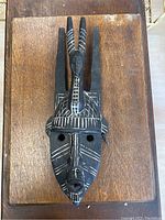 Full view of the hand carved African tribal wooden mask with detailed white painted linear designs on black wood, showing elongated features and top ornamental horns.