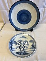 View of both vintage Japanese blue and white plates showing size difference and overall condition.