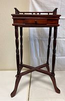 Front view of the wooden occasional table with drawer and turned legs.