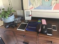 Wide shot showing binocular glasses, tablet, Kindle, watches, cases, wallet, bags, coins and phone