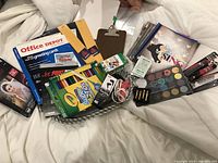 Photo showing the pewter bowl filled with various office and craft supplies including markers, notebooks, papers, face paint palette, and small electronics.
