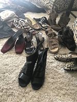 Overview of all shoes and cropped pants laid out on carpet, showing various shoe styles and some pants