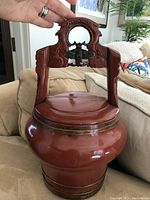 Front view of Ming Dynasty antique Chinese wedding basket, shows curved lacquered body and carved handle with metal bee decoration.