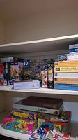 Shelf with multiple unopened and used board games including Frustration, Checkers, and others, assorted puzzle boxes visible.