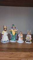 Four Royal Doulton Bunnykins porcelain figurines posed together on shelf, showing full front view.