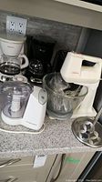 Photo showing Sunbeam stand mixer, Hamilton Beach food processor, two coffee makers and toaster on countertop.