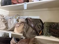 Six bags and purses arranged on shelves showing styles, materials, and colors.