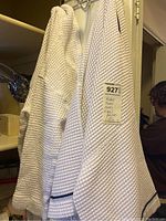 Two white waffle textured robes hanging with a MaxSold tag