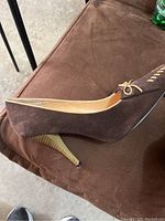 Brown suede high heel shoe with bow detail on side, showing side profile