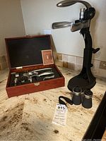 Two wine openers: boxed rabbit-style opener with accessories and black metal table corkscrew opener.