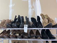 Two shelves with 10 pairs of women's shoes and boots, variety of styles and colors shown