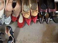 Top view of eight pairs of women's shoes arranged in two rows showing colors and styles.