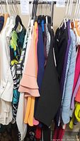 Photo of assorted women's blouses and sweaters on hanger, size small, mixed colors and patterns.