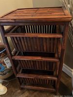 Front view of the bamboo stand showing the three basket drawers vertically stacked in a rectangular bamboo frame.