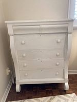 Front view of six-drawer white painted dresser showing round knobs and keyholes.
