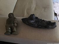 Both soapstone carvings placed side by side on a beige surface, showing their scale and overall appearance.