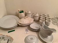 Full display of the lot showing casserole, tea pot, sugar dish, jug, cups, plates and platters.