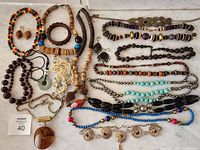 Overview of all sixteen jewelry pieces arranged on white surface