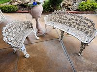 Overview of both benches, planter on pedestal, and watering globe