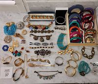 Overview of all bracelets, bangles and brooches on marble surface