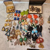 General display of assorted clip-on earrings on marble surface