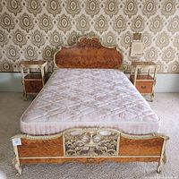 Full size bed frame with headboard and footboard flanked by two nightstands and mattress