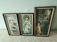 Three framed Margaret Keane giclee prints leaning against wall: one large and two smaller