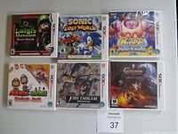 Six Nintendo 3DS game cases displayed on white surface: Luigi's Mansion: Dark Moon; Sonic Lost World; Kirby Planet Robobot; Mario & Luigi: Paper Jam; Fire Emblem Awakening; Castlevania: Lords of Shadow – Mirror of Fate.