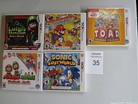 Photo of five Nintendo 3DS game cases including Luigi's Mansion Dark Moon, Paper Mario Sticker Star, Captain Toad: Treasure Tracker, Mario & Luigi: Paper Jam, and Sonic Lost World.