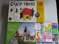 Photo of the lot showing boxed sets of Crazy Forts, Ring Toss game, and Balloon Modelling kit.