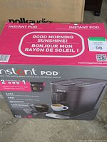 Box showing front of the Instant Pod coffee and espresso maker with 2-in-1 functionality, compatible with K-Cup pods and Nespresso capsules.