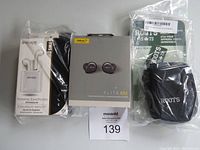 Photo of product bundle showing Jabra Elite 85t earbuds box, Escape wireless earphones box, and Roots small camera bag in plastic packaging.