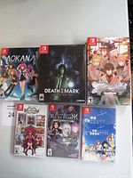 Six Nintendo Switch game cases arranged in two rows of three. Visible titles include Aokana, Death Mark Limited Edition, Labyrinth of Refrain, Fallen Legion and two other anime-style covers.