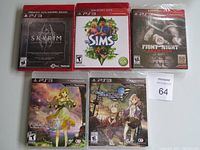 Photo showing front covers of five PS3 games in cases lying flat: Skyrim, The Sims 3, Fight Night Champion, Atelier Ayesha, and Atelier Escha & Logy.