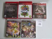 Five PS3 game cases including Skyrim Legendary Edition, Sims 3, Fight Night Champion, Atelier Ayesha, and another RPG game with anime-style art