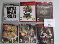 Photo showing six PS3 game cases arranged in two rows of three. Titles include Metal Gear Solid: The Legacy Collection, The Sims 3, Skyrim, Atelier Totori, Atelier Meruru, and Fight Night Champion. All cases appear sealed in plastic, new condition.