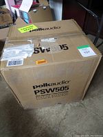 Closed cardboard shipping box labeled “polkaudio PSW505” with caution sticker and lot tag.