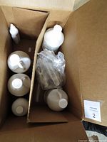 View inside box showing multiple white plastic bottles of cleaning concentrates and smaller spray bottle containers.