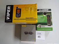 Photo showing the Viper remote start system in its yellow box, Jabra Elite 85t earbuds box, and an AlcoHAWK Ultra Slim breathalyzer in packaging.