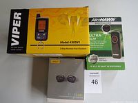 Photo of Viper 2-Way Remote Start System box, Jabra Elite 85t earbuds box, and AlcoHAWK Ultra Breathalyzer package on white surface.