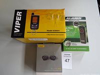 Photo showing Viper 2-way remote start system box, Jabra Elite 85t earbuds box, and AlcoHAWK Ultra breathalyzer package arranged on table.