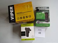 Photo showing boxed Viper 2-way remote start system, Alcohawk breathalyzer, Jabra 85t earbuds, and QuikMagnet vent phone mount.